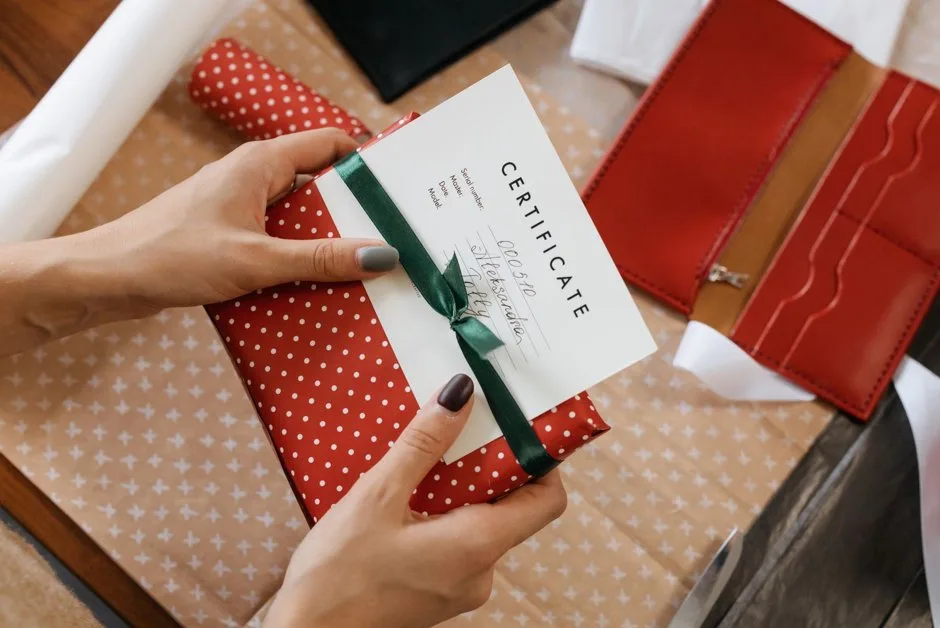 Chèque cadeau Cadhoc posé sur un comptoir de caisse, à côté d'articles de mode prêts à être payés